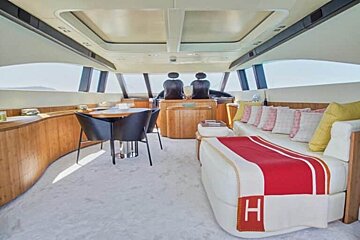 The interior of a yacht with a couch , table and chairs