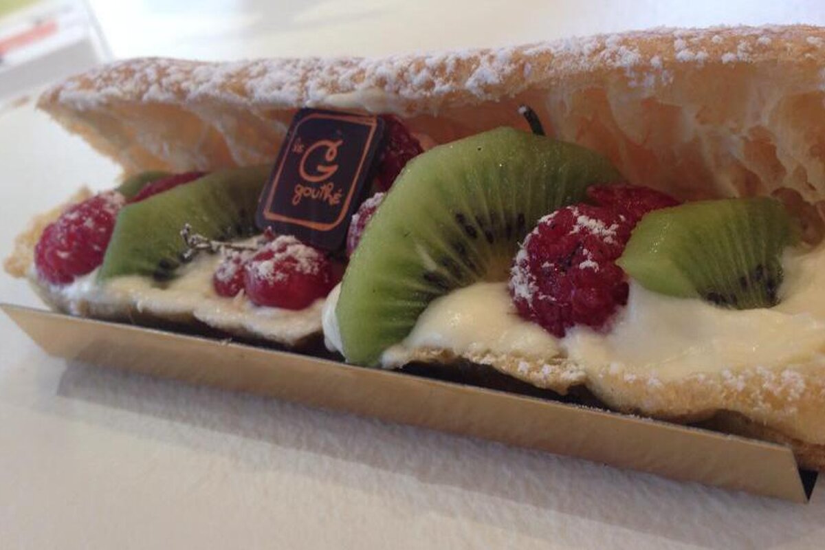 a cake with kiwis and raspberries in