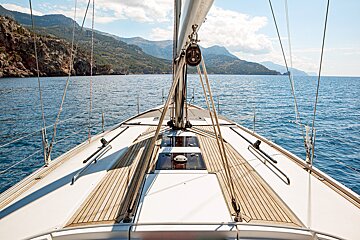 A sailboat in the ocean with mountains in the background