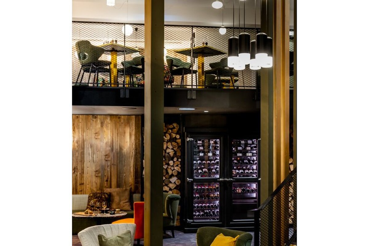 A restaurant with tables and chairs and a wine cooler