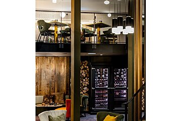 A restaurant with tables and chairs and a wine cooler