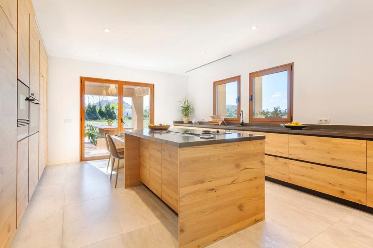A kitchen with wooden cabinets and a large island
