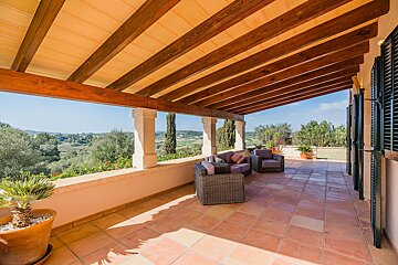 A balcony with a view of a lush green field