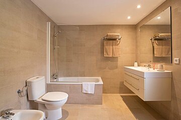 A bathroom with a toilet a sink and a bathtub