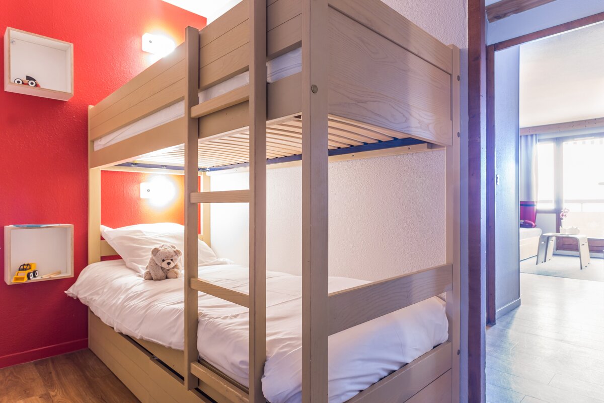 A bunk bed with a teddy bear on it