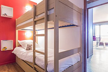 A bunk bed with a teddy bear on it