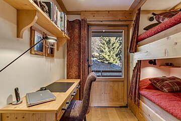 A wooden desk with an apple laptop on it