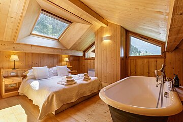 A bedroom with a king size bed and a bathtub