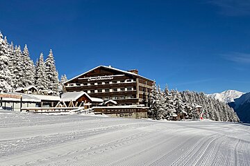 A snowy landscape with a large building that says continental