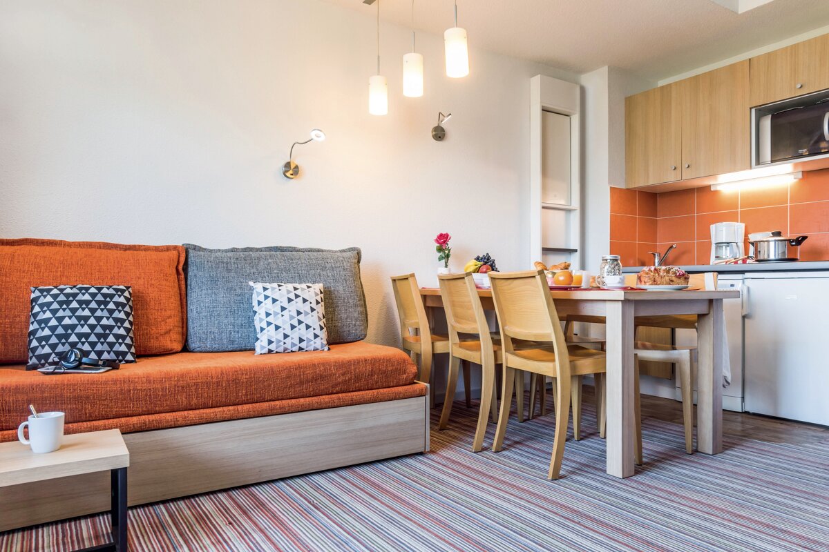A living room with a couch and a table and chairs