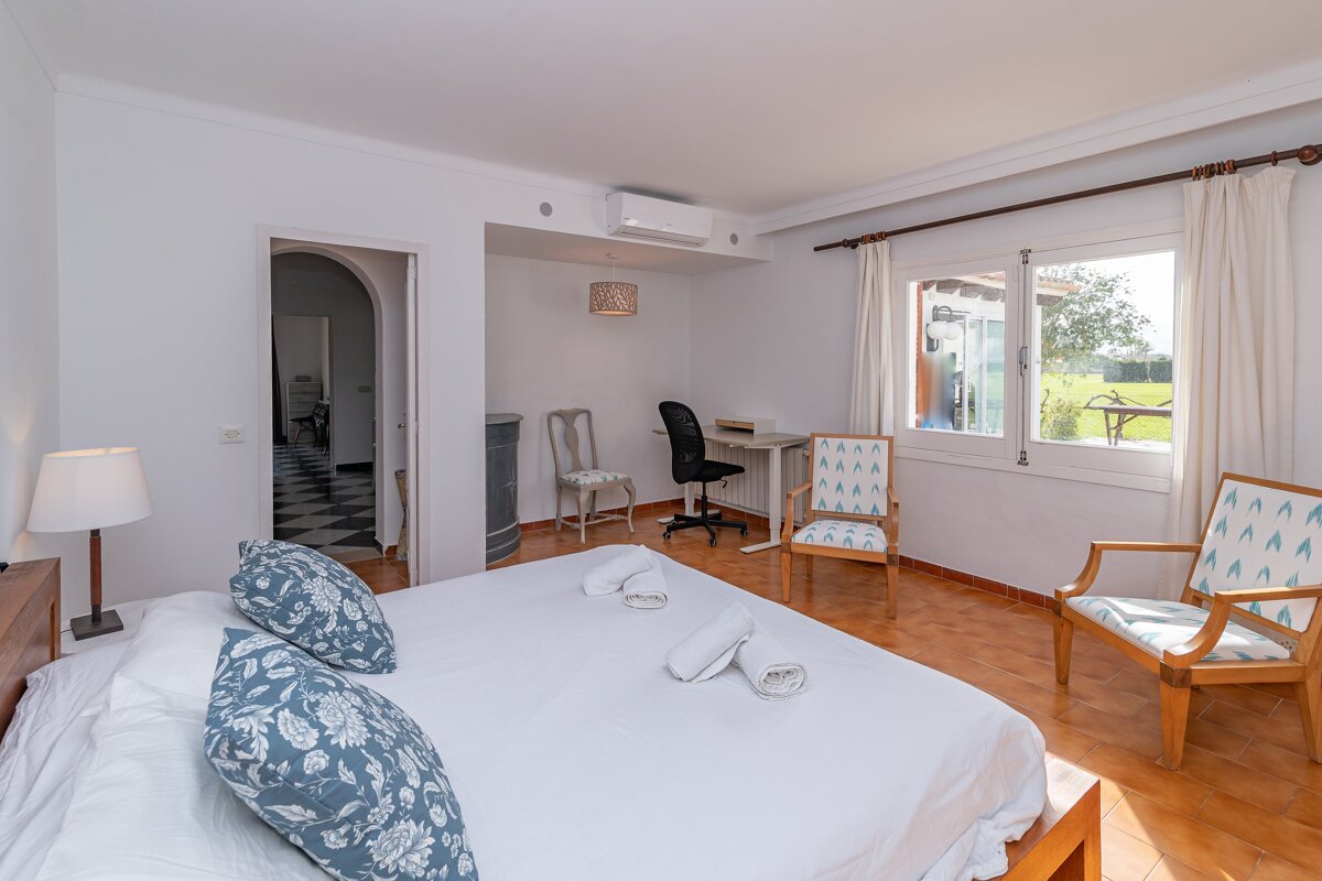 A bedroom with a large bed and two chairs