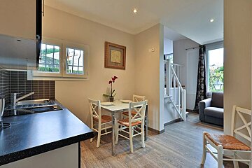A kitchen with a table and chairs and a picture on the wall