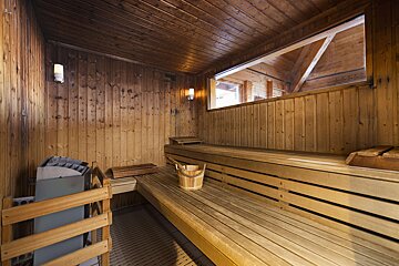 A wooden sauna with a bucket on the bench