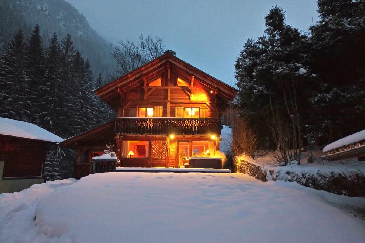 A snowy house with a hot tub in front of it