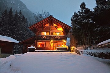 A snowy house with a hot tub in front of it