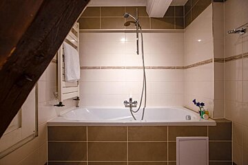A bathroom with a bathtub and a shower head