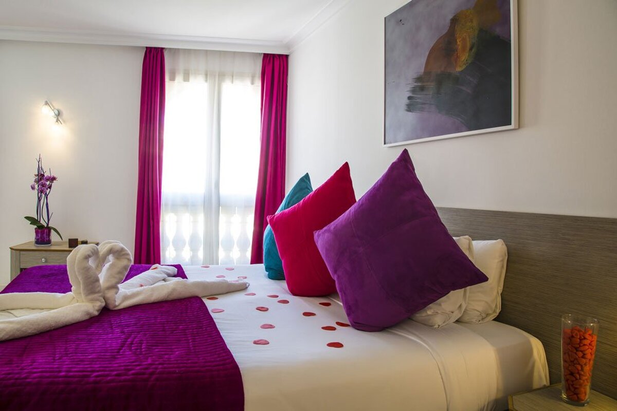 A bed with purple pillows and a purple blanket