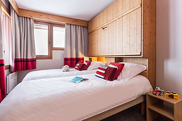 A bedroom with two beds and a nightstand with a toy truck on it