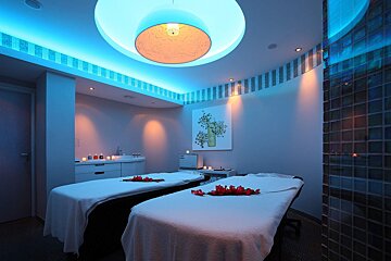 Two massage tables in a room with blue lights