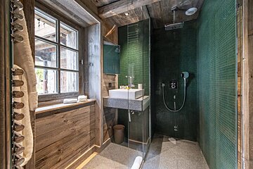 A bathroom with green tiles and a sink
