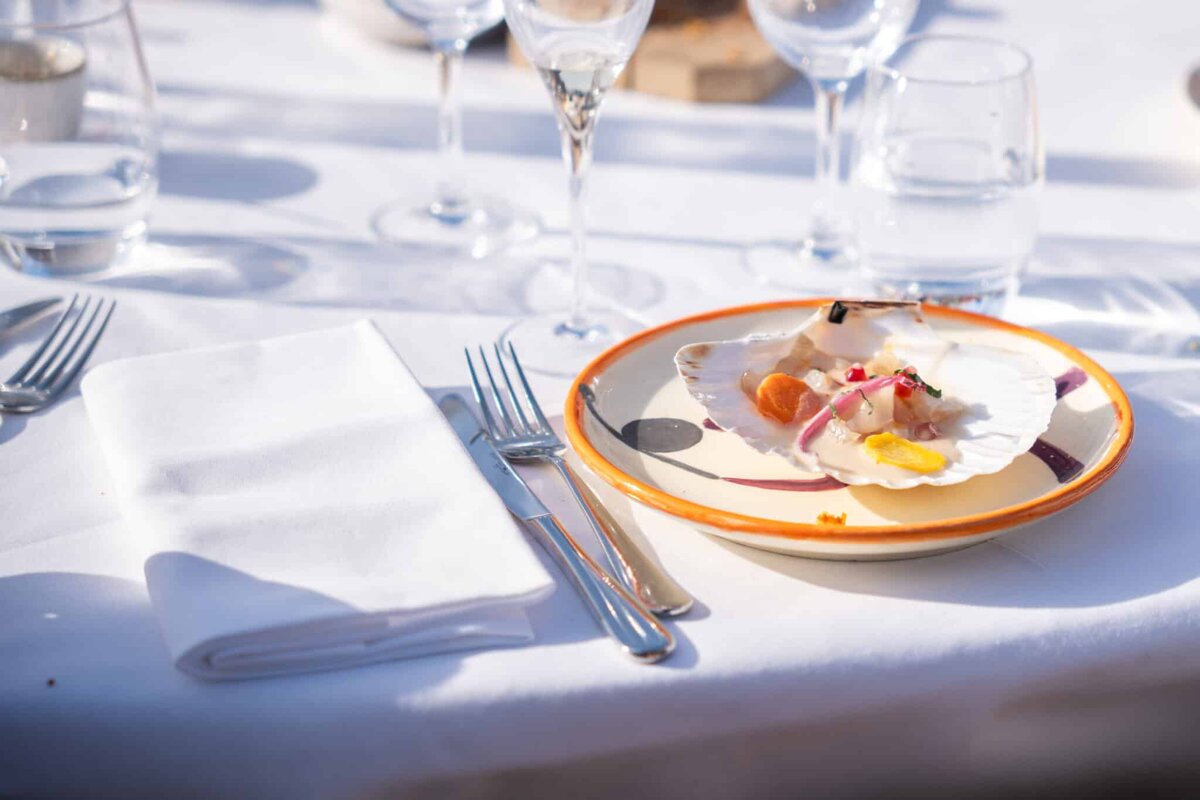 A plate of food on a table with wine glasses