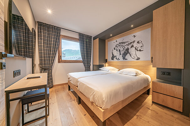 A bedroom with two beds and a bear painting on the wall