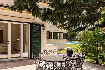 A patio with a table and chairs in front of a house