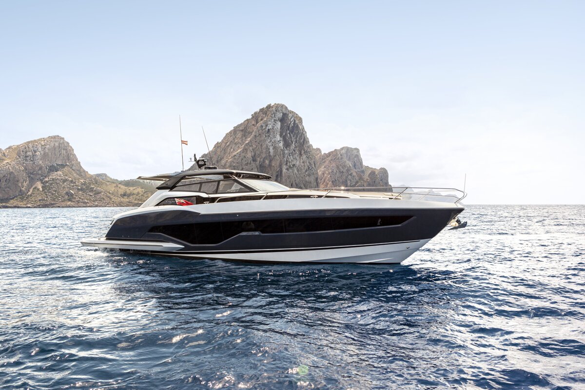 A boat is floating in the ocean with a mountain in the background