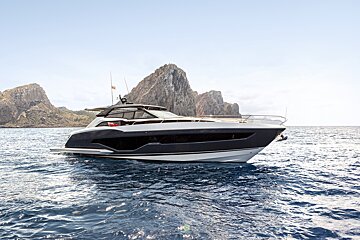 A boat is floating in the ocean with a mountain in the background
