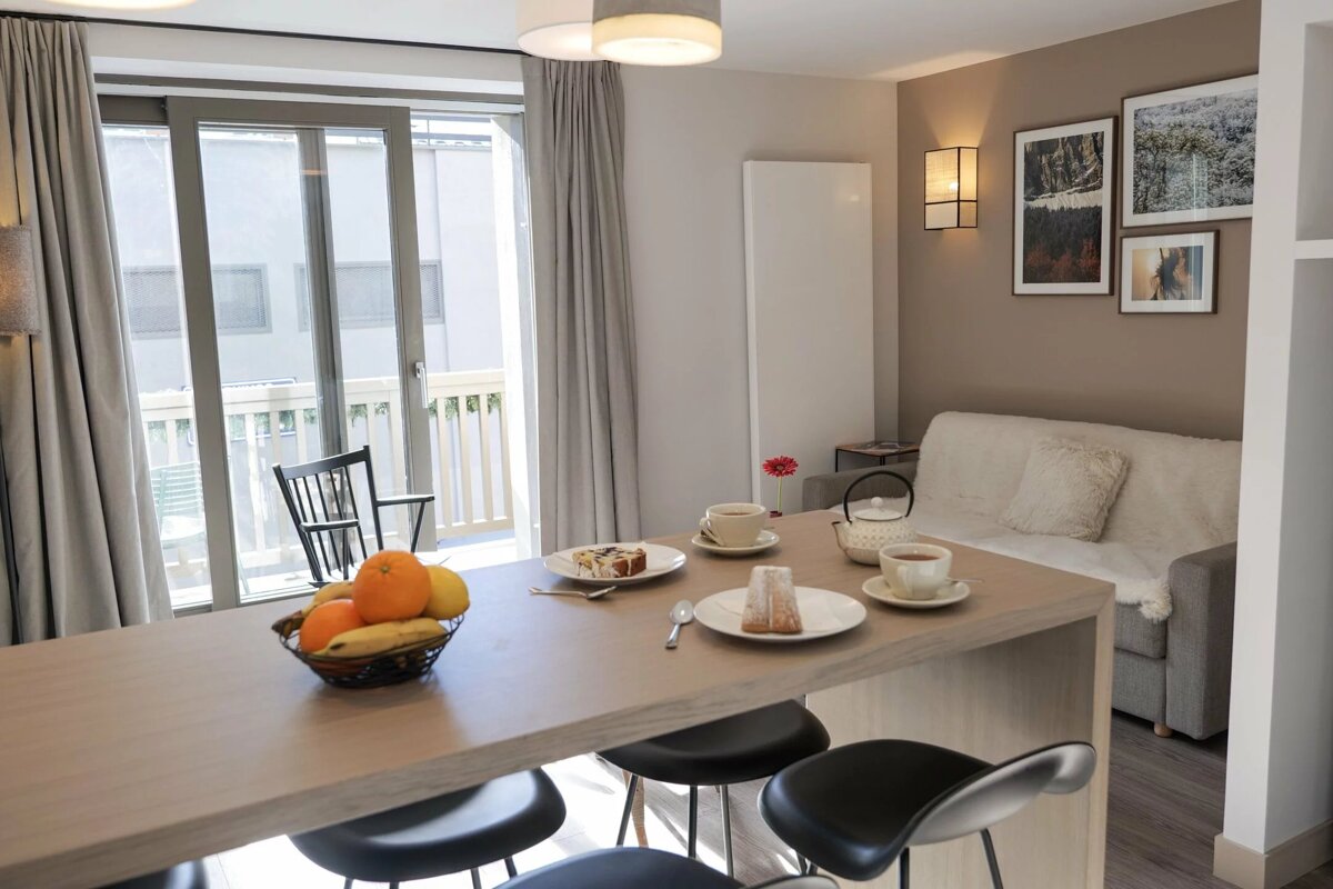 A table with plates of food and a bowl of fruit on it