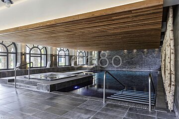 A large indoor swimming pool with the number 80 on the wall