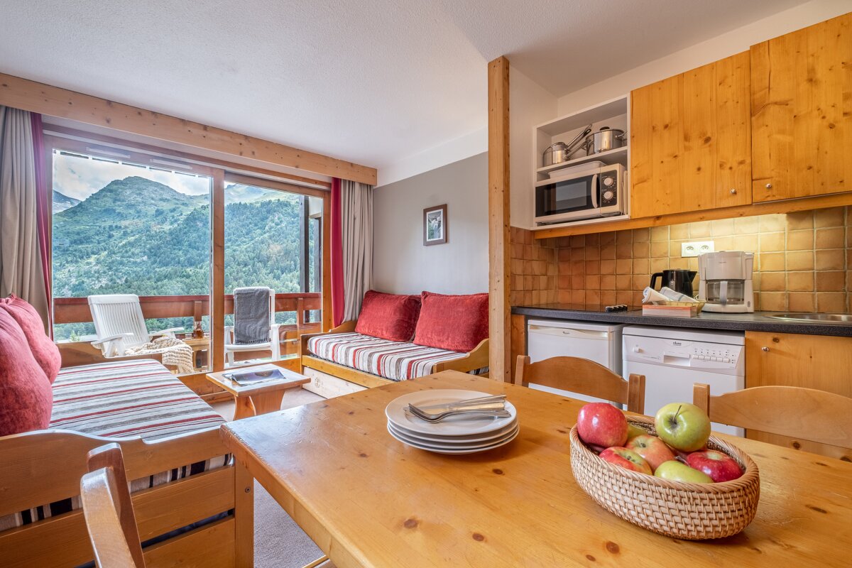 A wooden table with a basket of apples on it