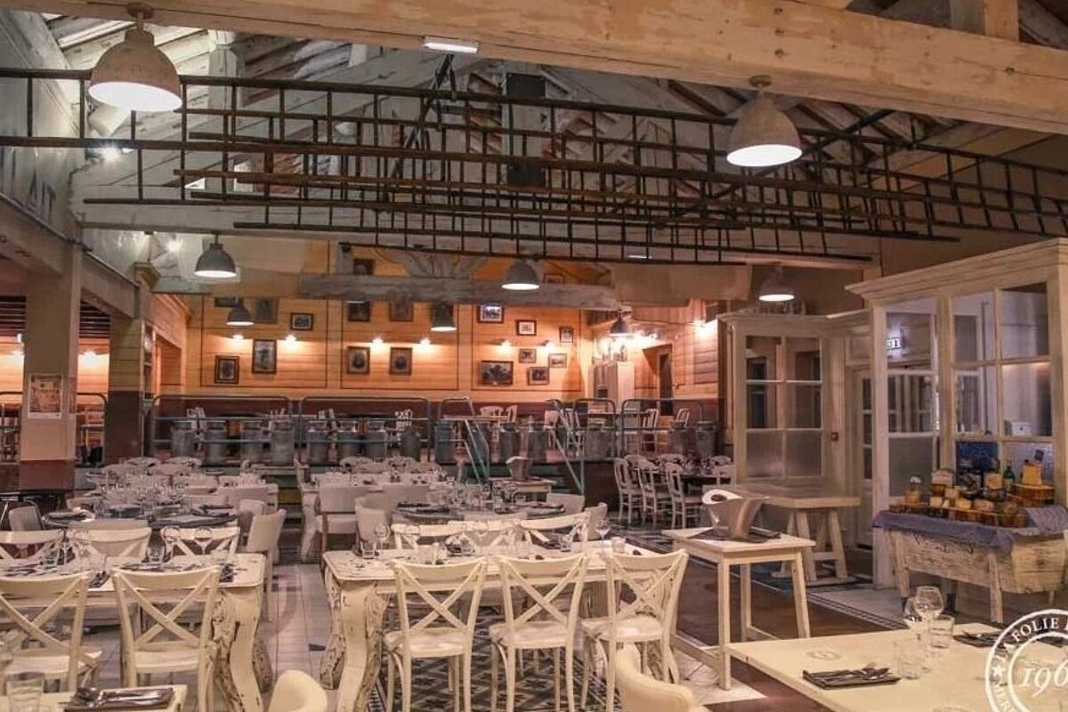 The inside of a restaurant with tables and chairs and the year 1908