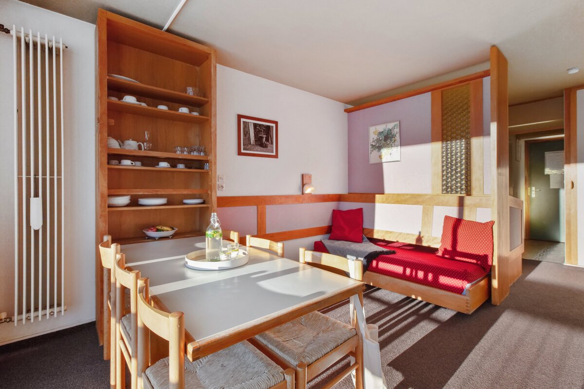 A living room with a table and chairs and a picture on the wall