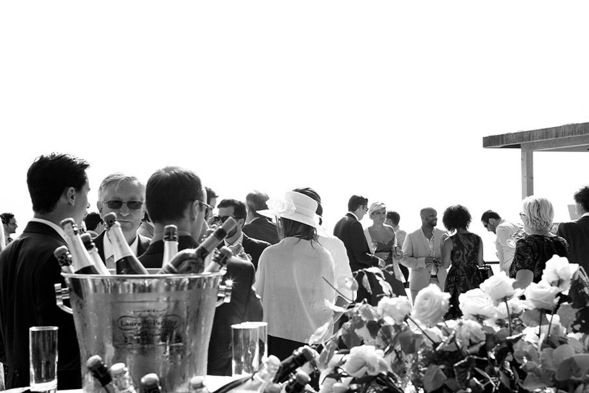 A group of people are gathered around a bucket of champagne