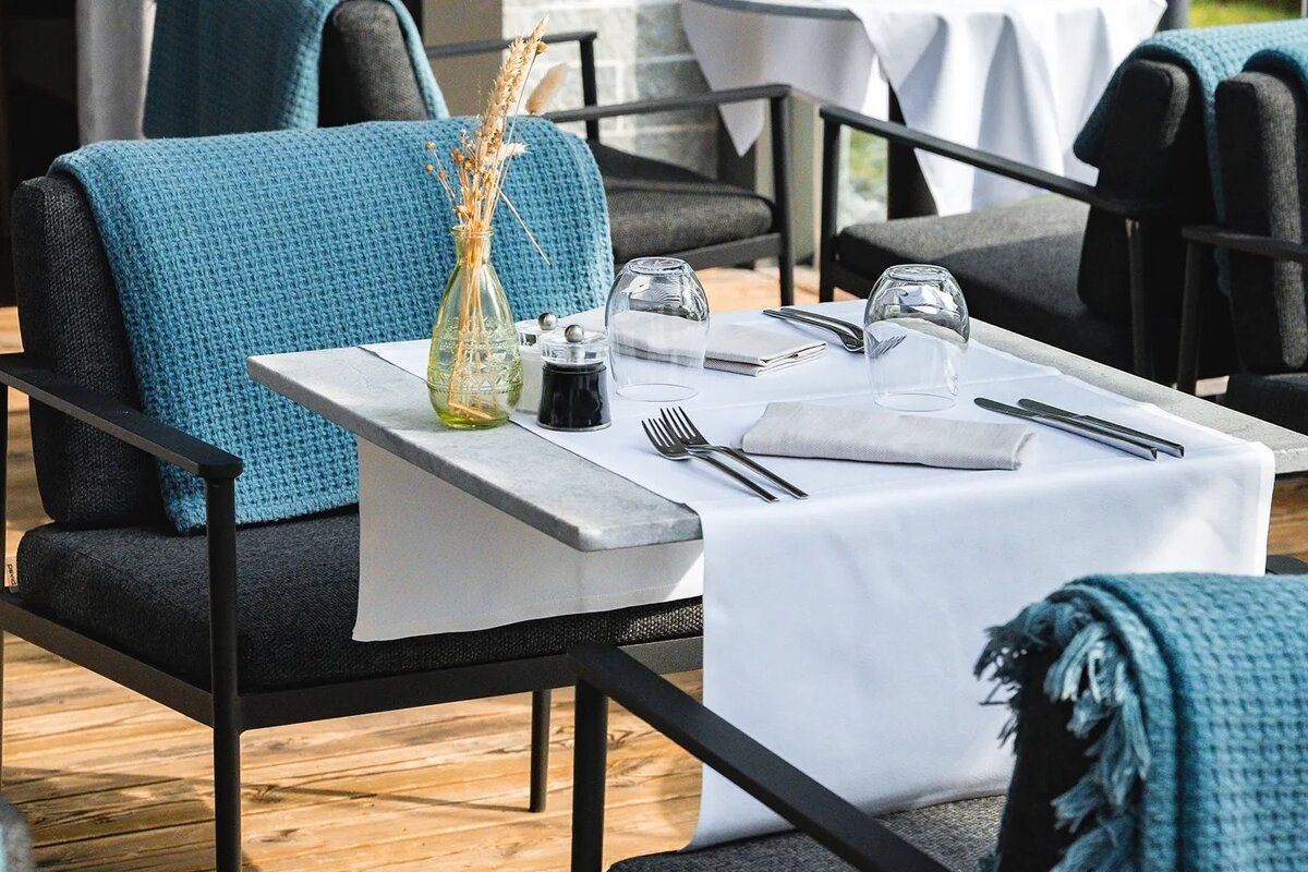 A table with a white table cloth and silverware on it