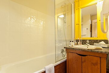 A bathroom with a sink and a yellow mirror