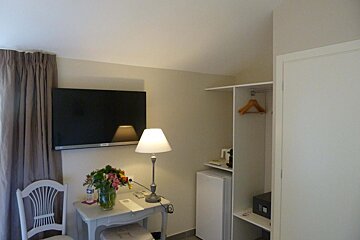 A hotel room with a flat screen tv and a lamp