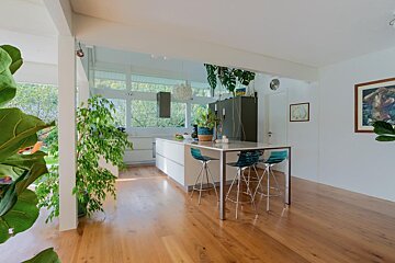 A kitchen with a table and chairs and a painting on the wall