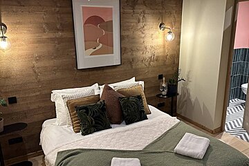 A bedroom with a picture on the wall above the bed