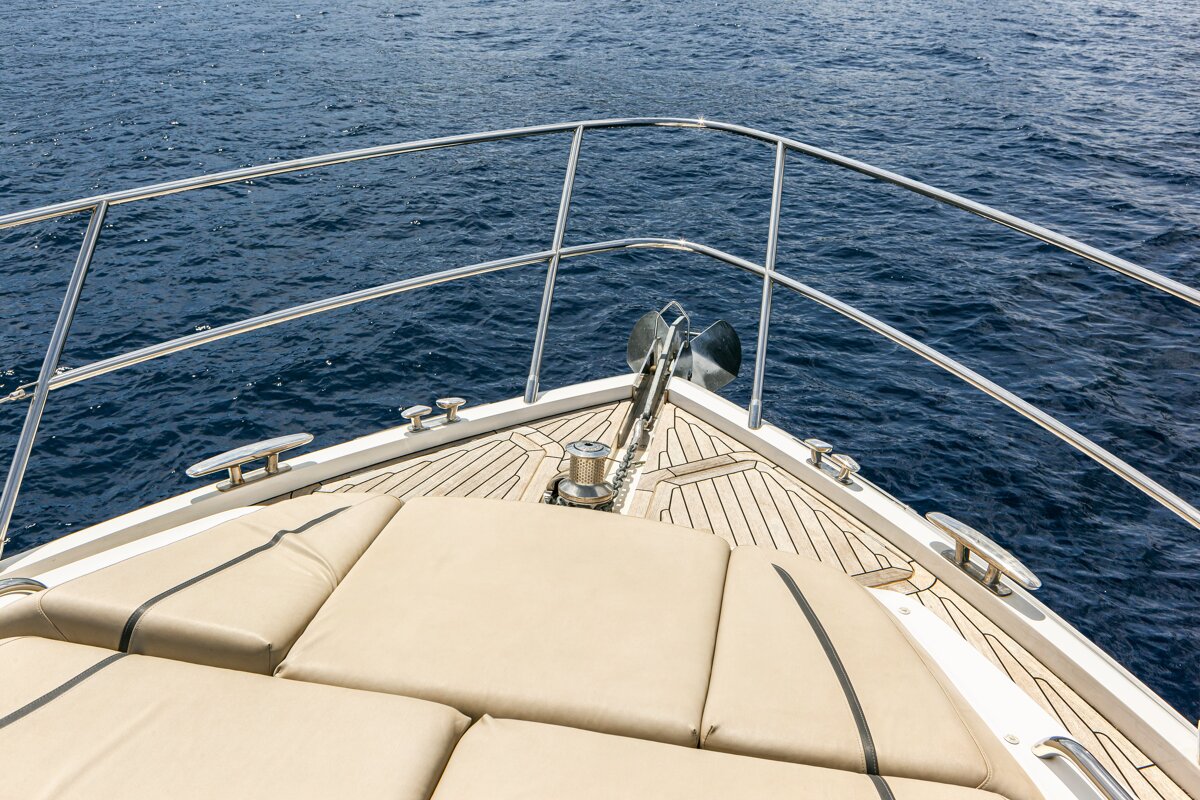 A boat with a stainless steel railing is floating on the water