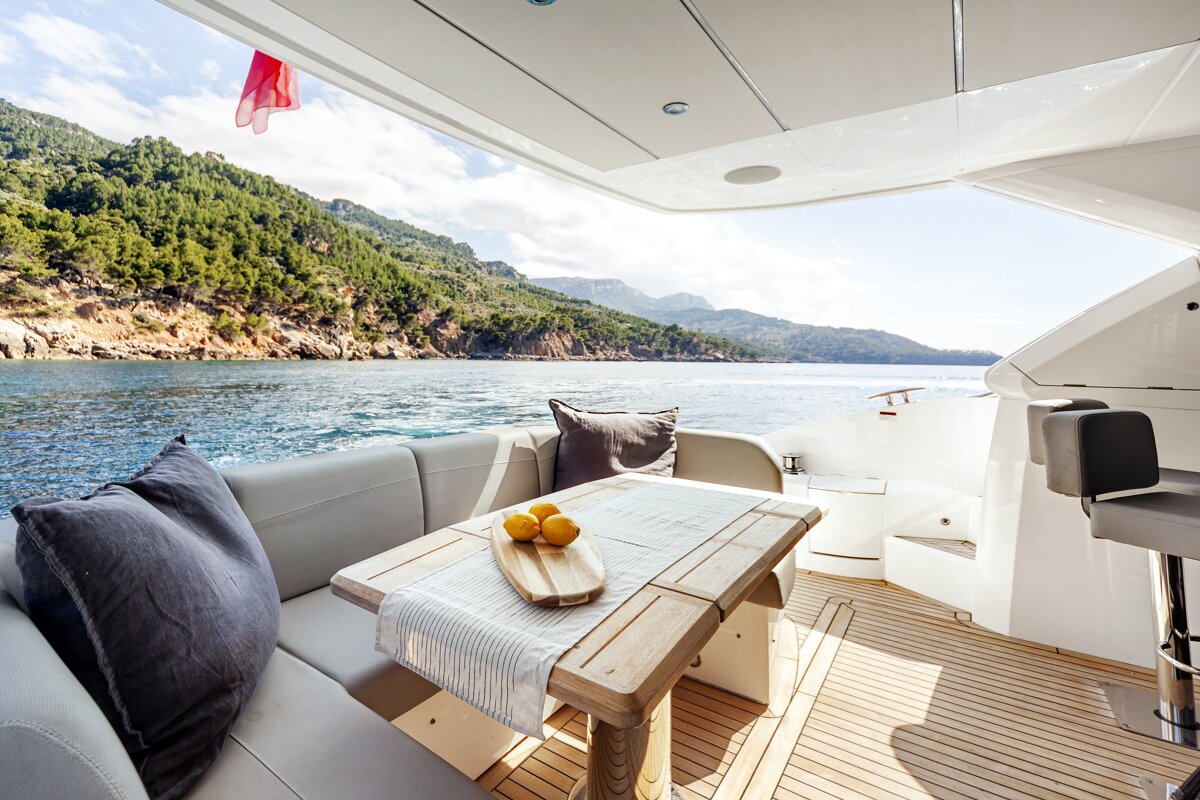 A wooden table with lemons on it sits on the deck of a boat