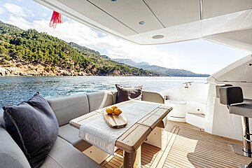 A wooden table with lemons on it sits on the deck of a boat