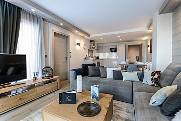 A living room with a couch and a book with the letter c on it