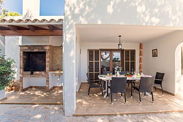 A patio with a table and chairs and a grill