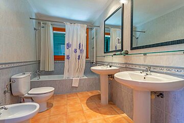 A bathroom with two sinks and a toilet