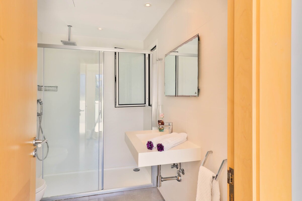 A bathroom with a sink and a walk in shower