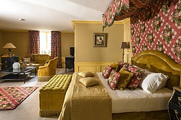 A bedroom with a canopy bed and a picture on the wall