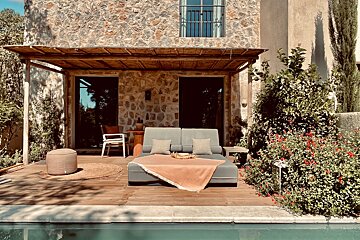 A couch sits on a deck next to a swimming pool