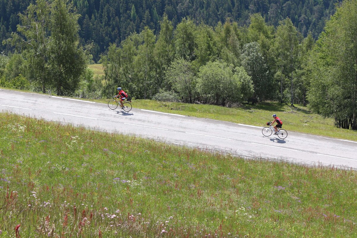 Two cyclists climbing col de Petit St Bernard